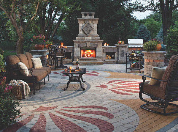 Outdoor patio with fireplace, bbq, and colored paver patterns.