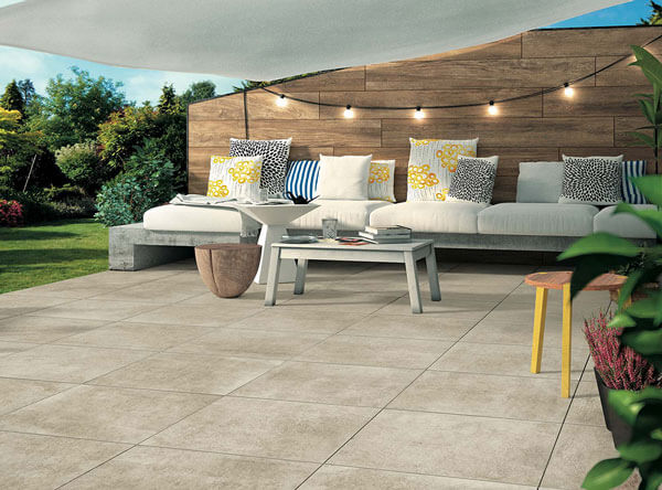 Modern patio with clean concrete, wood siding, and sail shade.