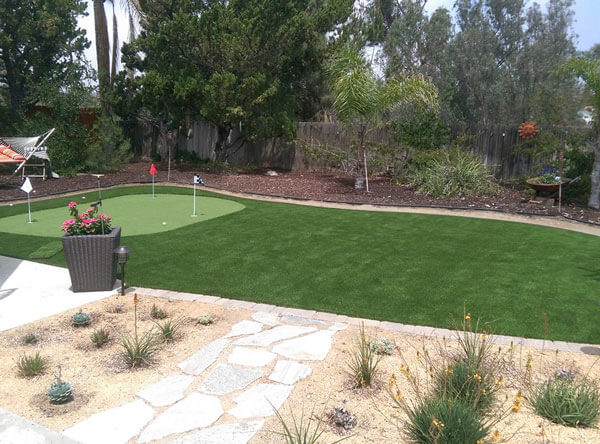 Putting green made of artificial grass with a hammock and drought resistant plants.