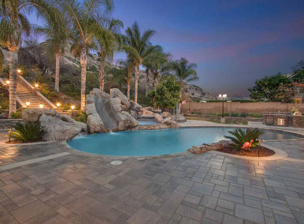 Pool area with slide and beautiful paving stones.