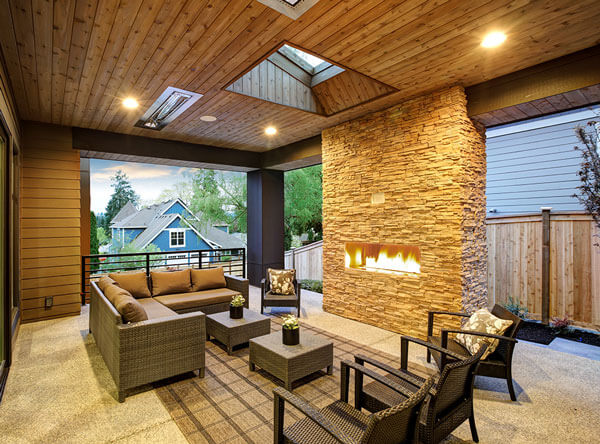 Covered patio connected to the home with heaters and a contemporary fireplace.