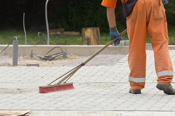 Worker cleaning pavers