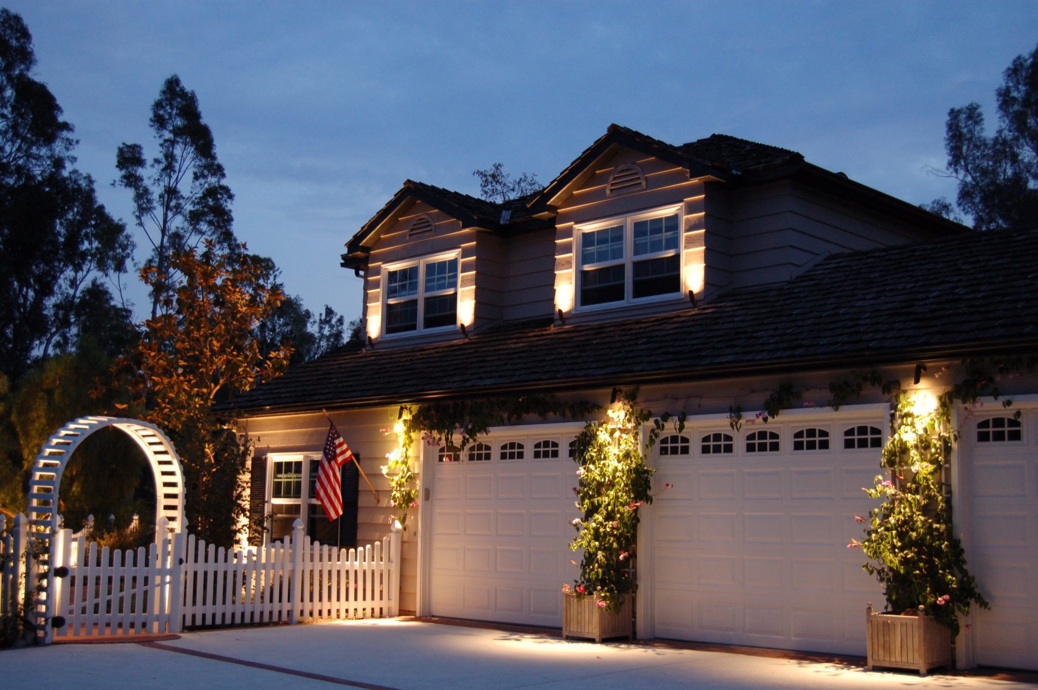 Front of house with outdoor lighting on home and walkway