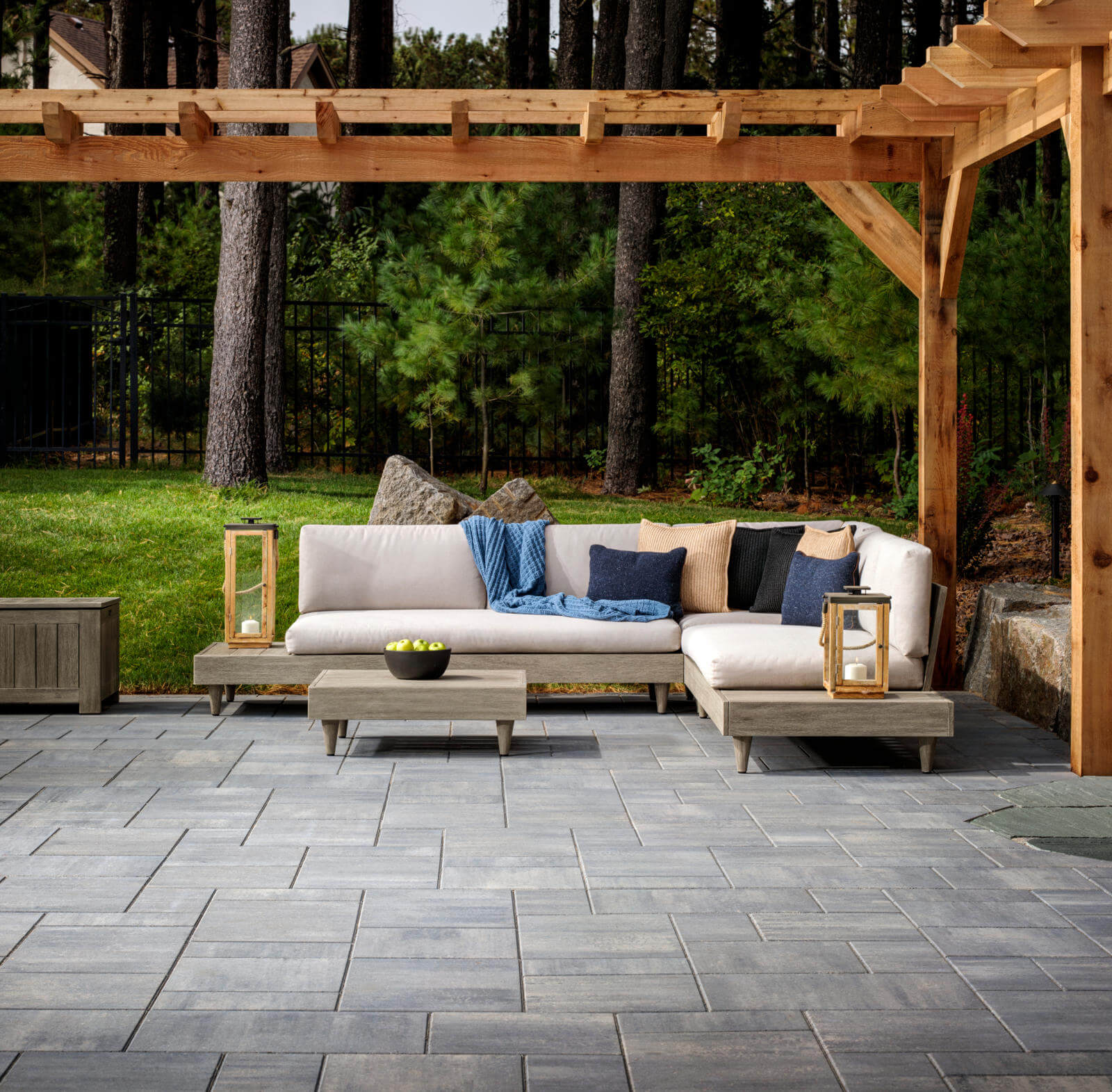 A patio with a wooden pergola and outdoor furniture