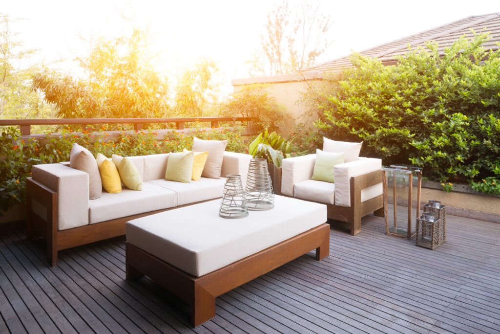 Backyard patio in Scripps Ranch, CA with white outdoor furniture and greenery. 