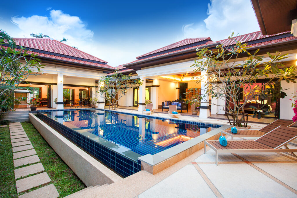 Backyard landscape design of a home in Santee, CA, with a large pool, hardscaping, and landscape lighting. 