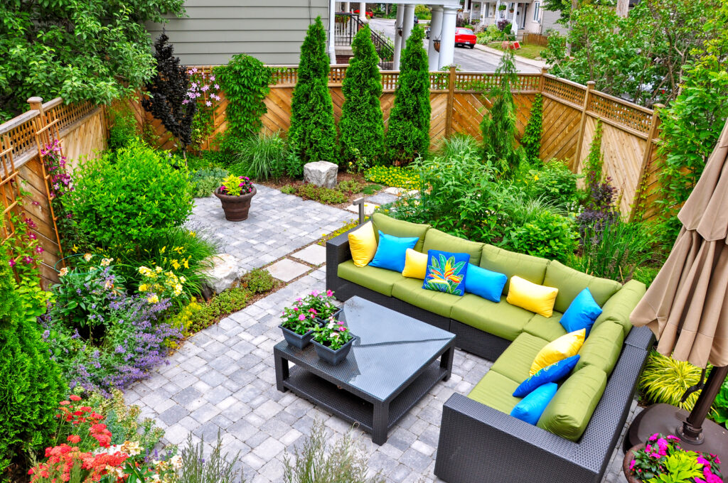 Hardscaped backyard in Bonsall, CA, featuring lime green outdoor furniture and greenery. 