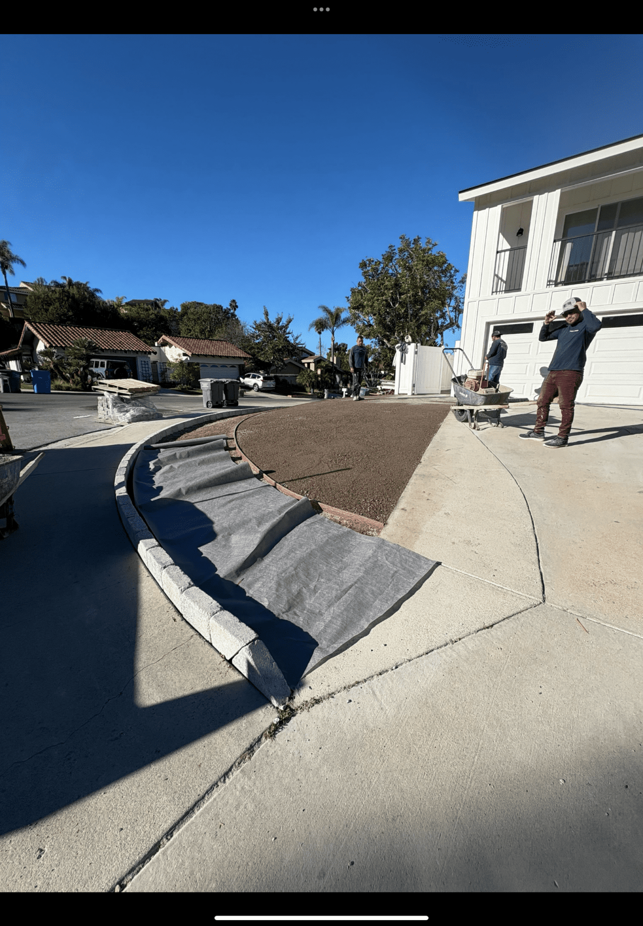 A low paver-on-edge border set in concrete along the front-yard island, with the planting bed graded behind it.