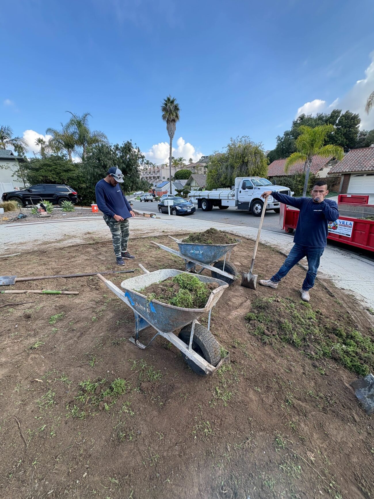 Site grading and soil removal underway in the front yard, with material hauled out to the curb.