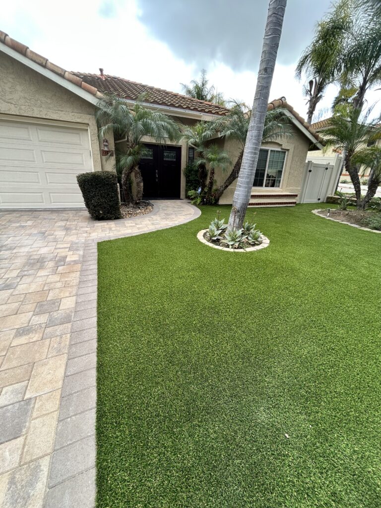 Front yard showing finished interlocking pavers driveway and a curved paver walkway transitioning to newly installed...