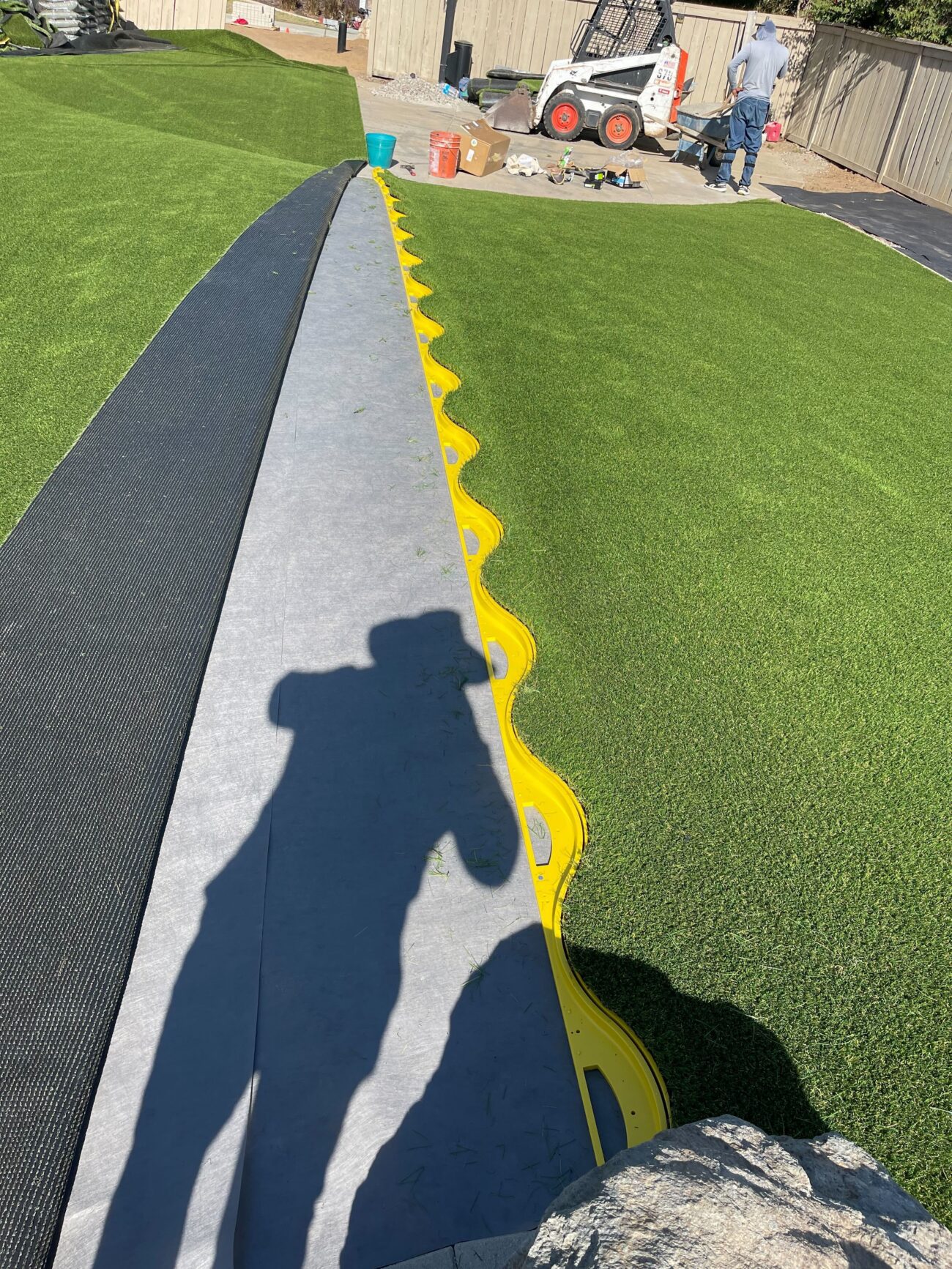 Artificial turf seam work underway before the finished field was brushed and tucked.