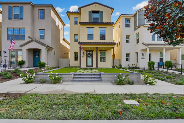 Wide front elevation with the terraced entry and lawn grid.