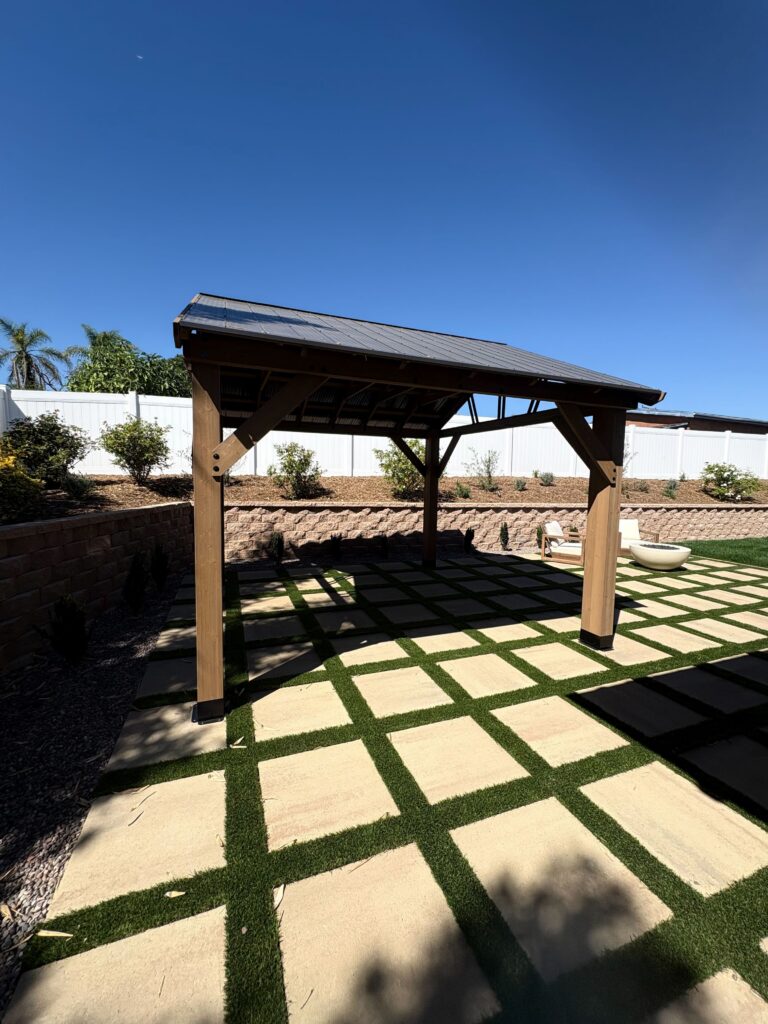 Timber pergola over the paver-and-turf checkerboard patio in a finished Vista backyard. Install It Direct project.