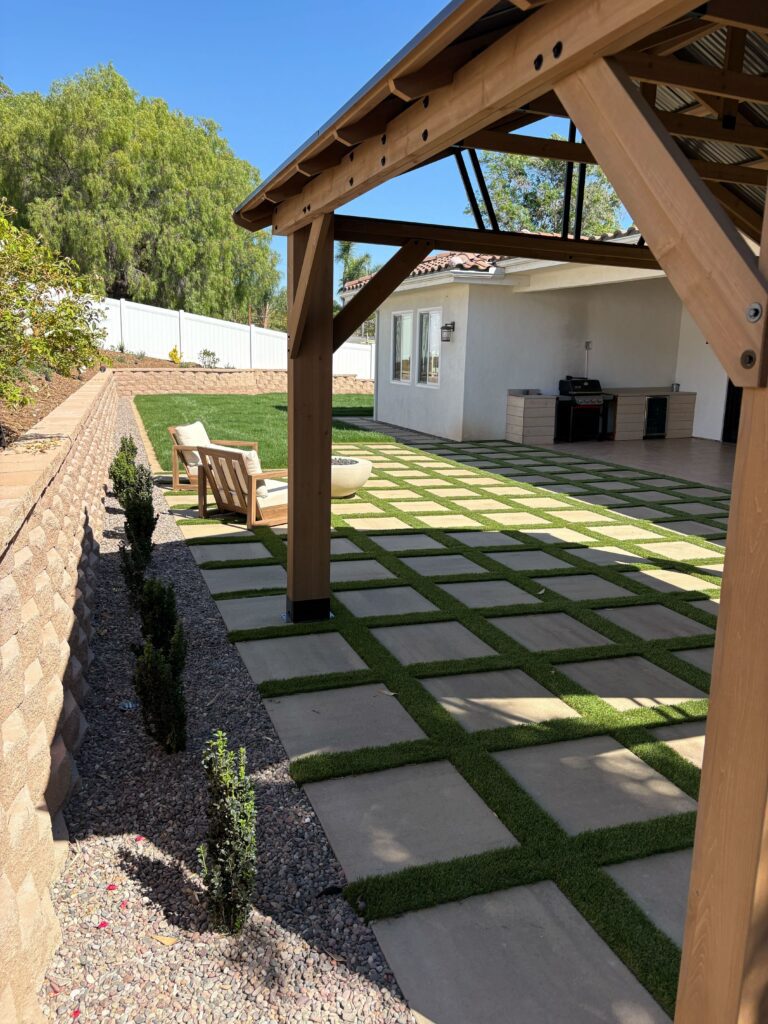 Pergola over the paver-and-turf patio with covered patio, fire feature, and segmental retaining wall in Vista, CA. Install It Direct project.