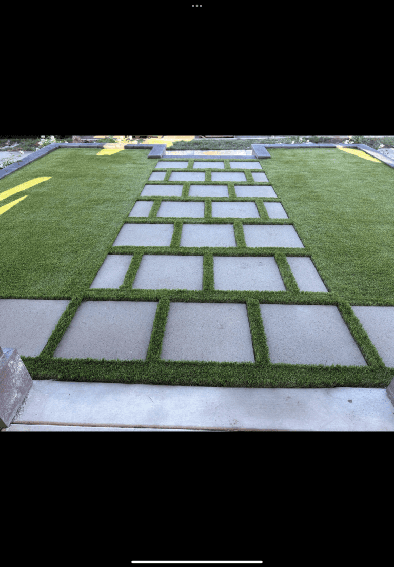 Large-format concrete pavers set in a rectangular grid pattern with artificial turf infill, forming a defined walkway/patio across a yard. Escondido project by Install It Direct.