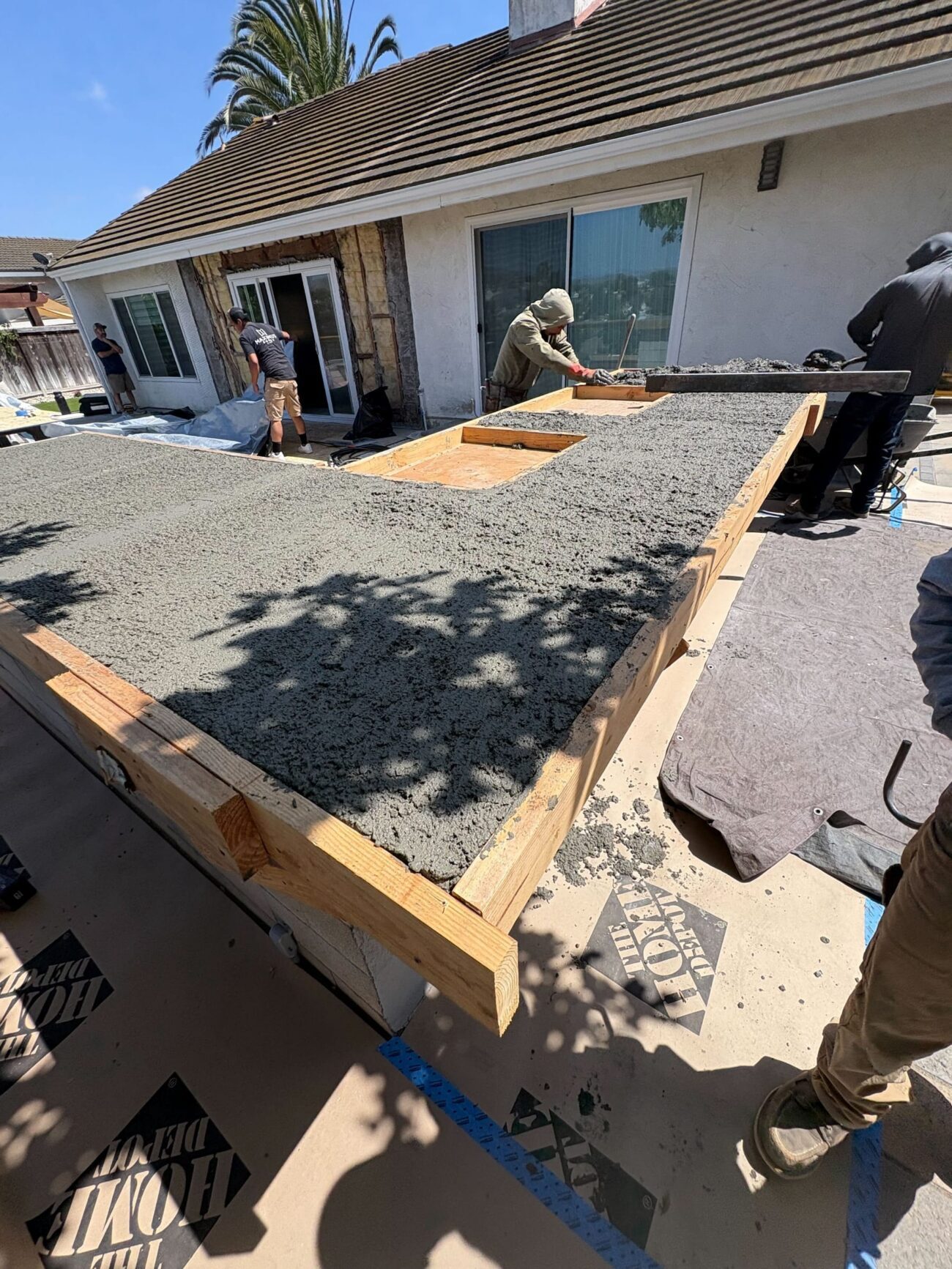 Crew pours and levels concrete inside the temporary counter forms.