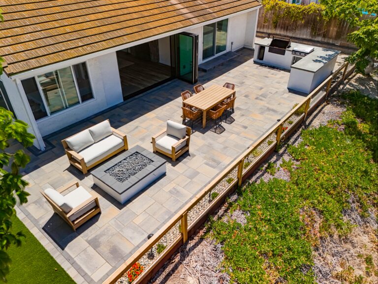 Aerial across the full paver patio, fire pit and outdoor kitchen island