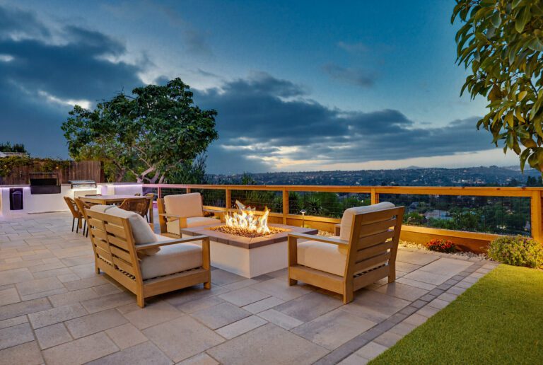 Gas fire pit ignites at twilight above the twinkling valley