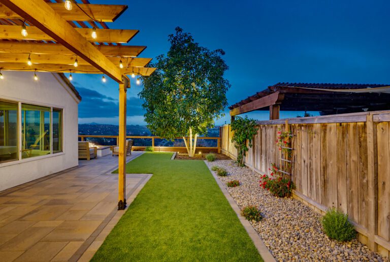 Landscape lighting washes the patio and turf after dark