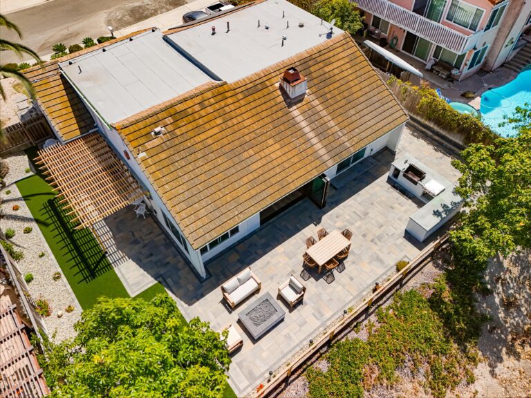 Top-down aerial revealing the complete patio, turf lawn and kitchen layout