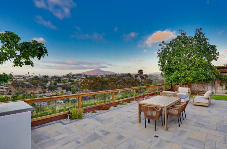 Six-seat dining table set against the open valley panorama