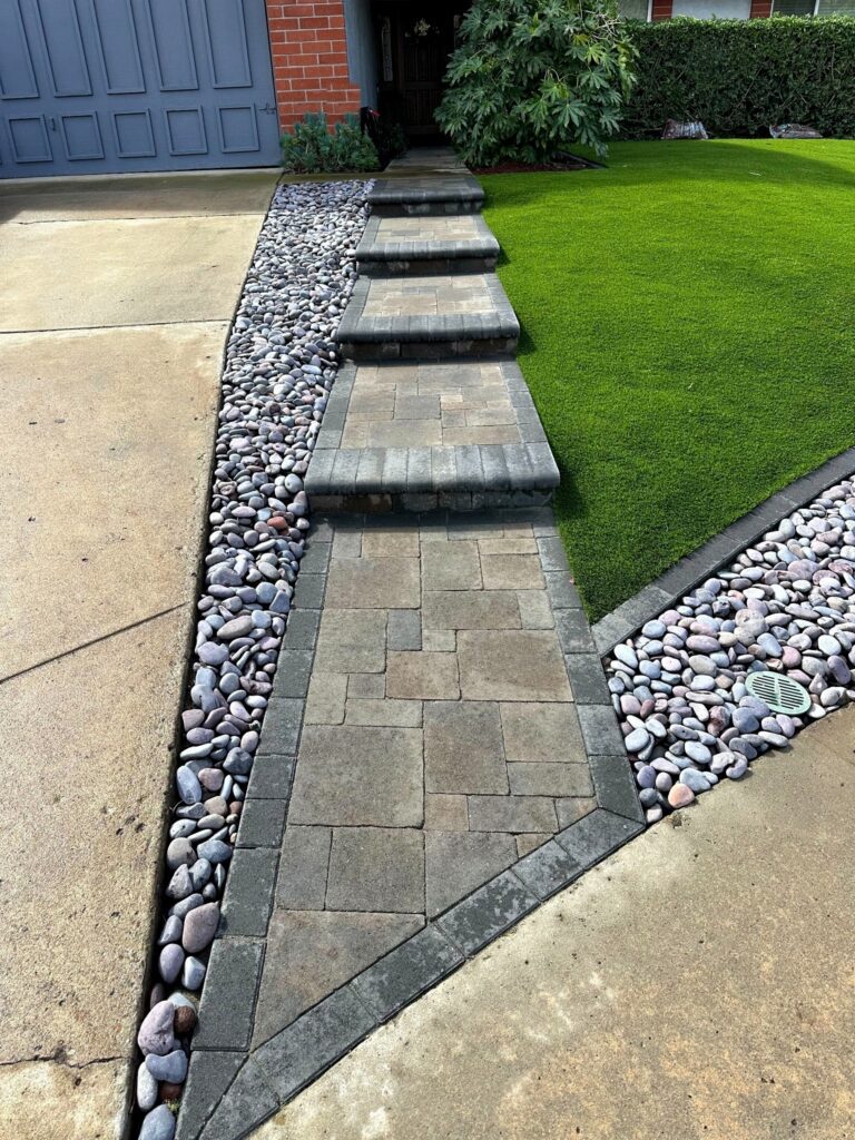 Soldier-course paver border meeting the existing concrete driveway with a single clean joint, Tierrasanta front yard.