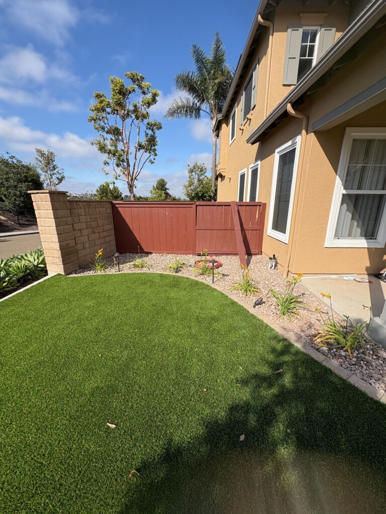 Side yard turf with a gravel bed and path lights along the fence