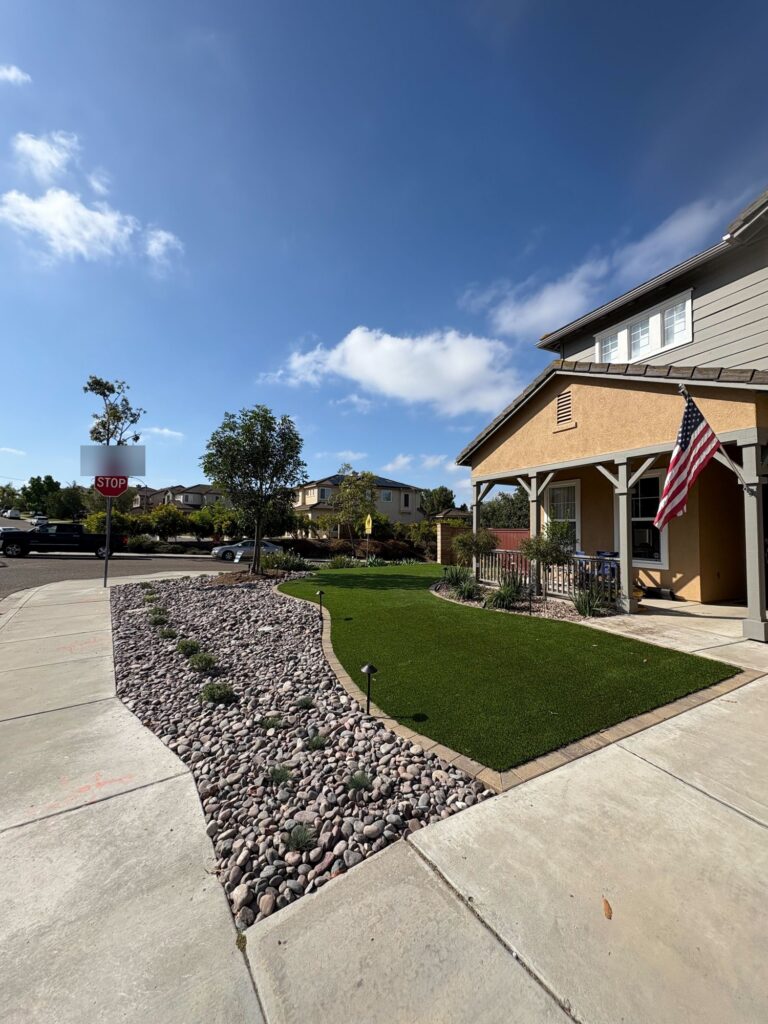 River rock, turf and a paver mow strip at the corner of the lot