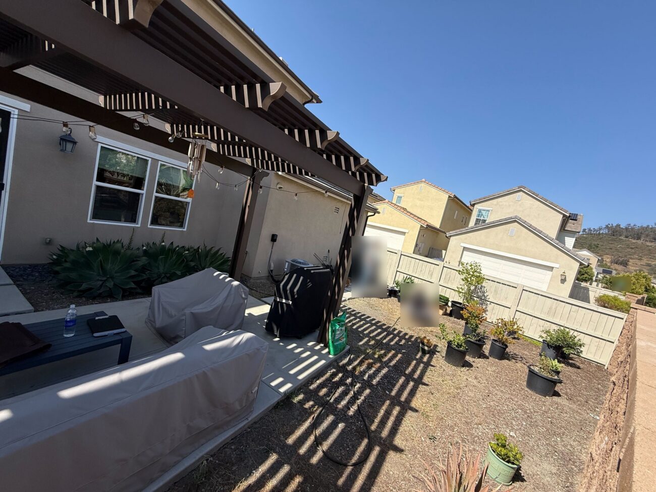 Before: a dirt backyard with plants in nursery pots along the fence, Escondido 92029