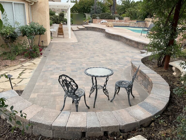 Paver patio with a curved seat wall and steps up to the pool deck, Poway 92064