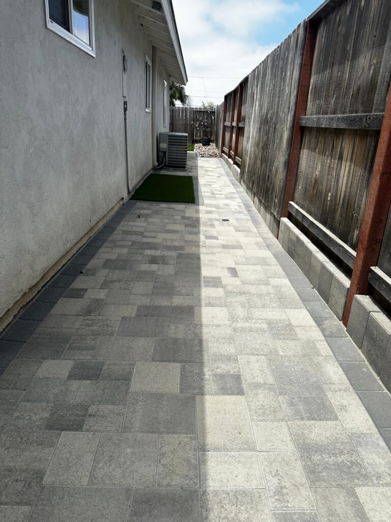 Pavers run the length of the side yard along the fence