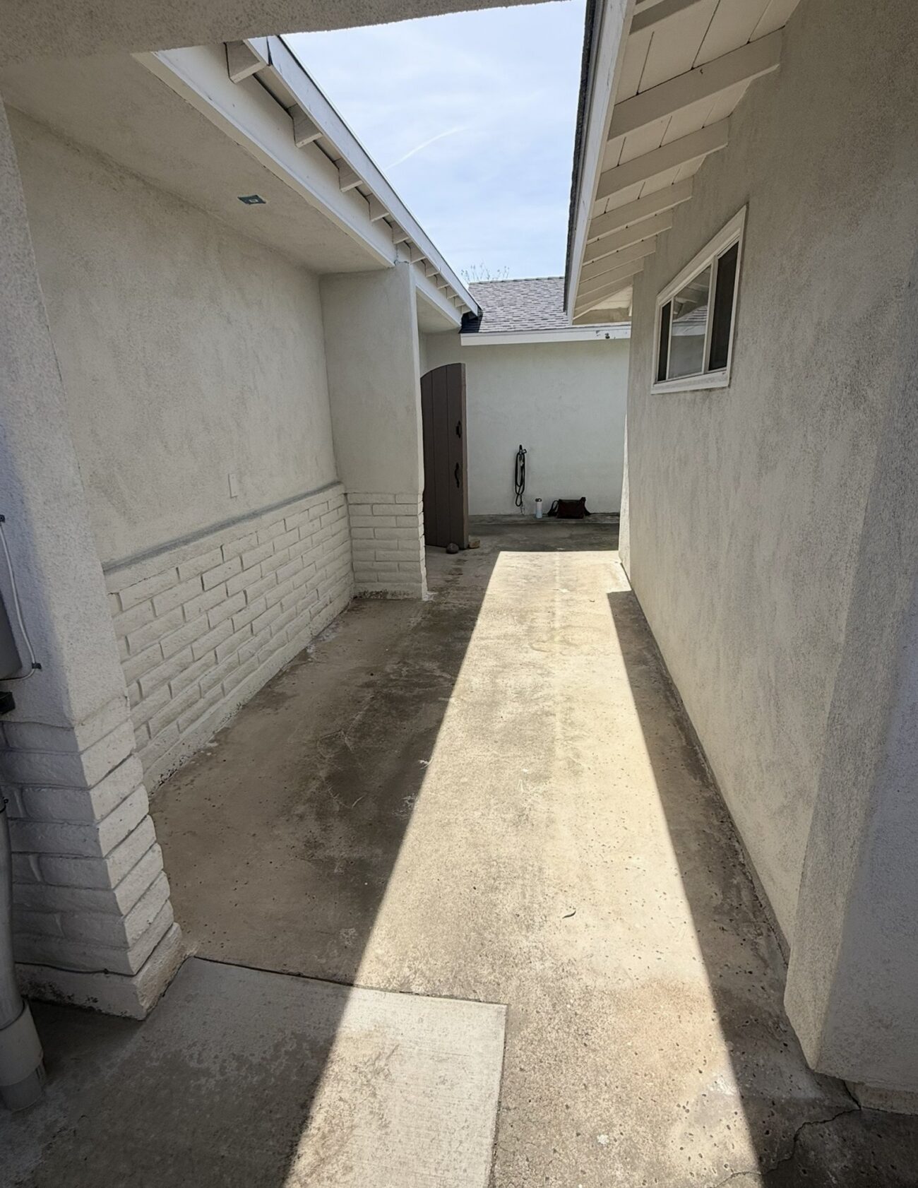 Before: a stained concrete walk between the two wings of the house