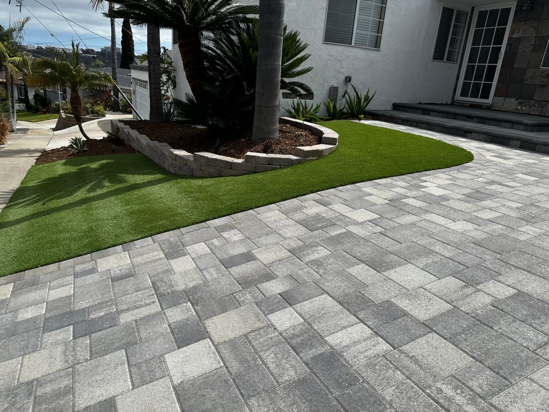 Angelus pavers, new turf and a curved block planter wall at the front walk
