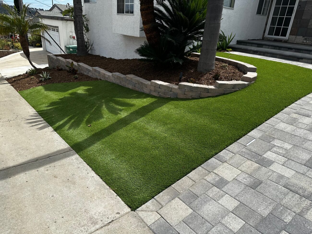 Turf and pavers meet at the curved planter wall