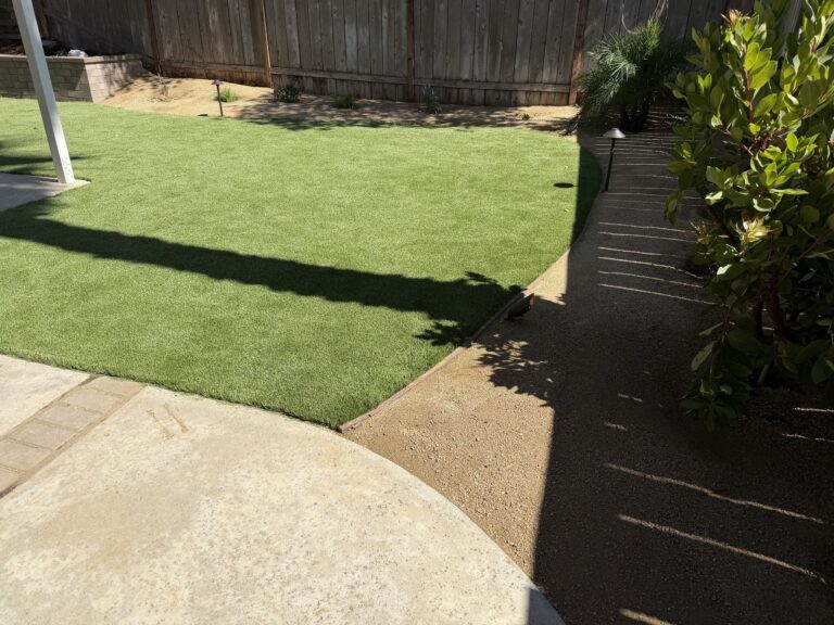 Existing concrete patio with a new 4x8 Holland paver ribbon where an old brick band was, meeting the turf and decomposed granite path