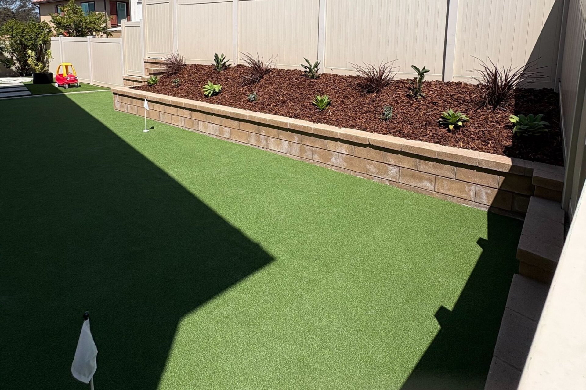 The side yard is now a putting green with three cups